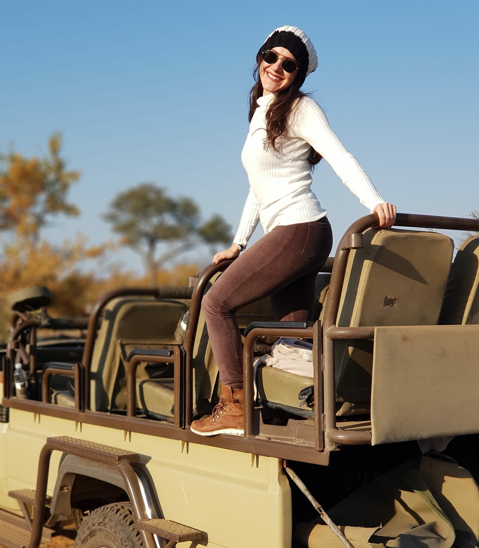 Mulher em pé em carro de safari na África do Sul