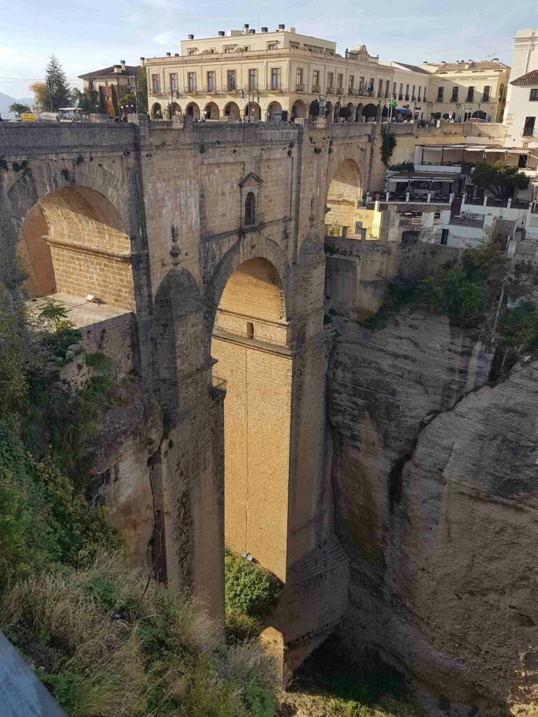 ponte antiga que fica entre dois paredões de pedra 