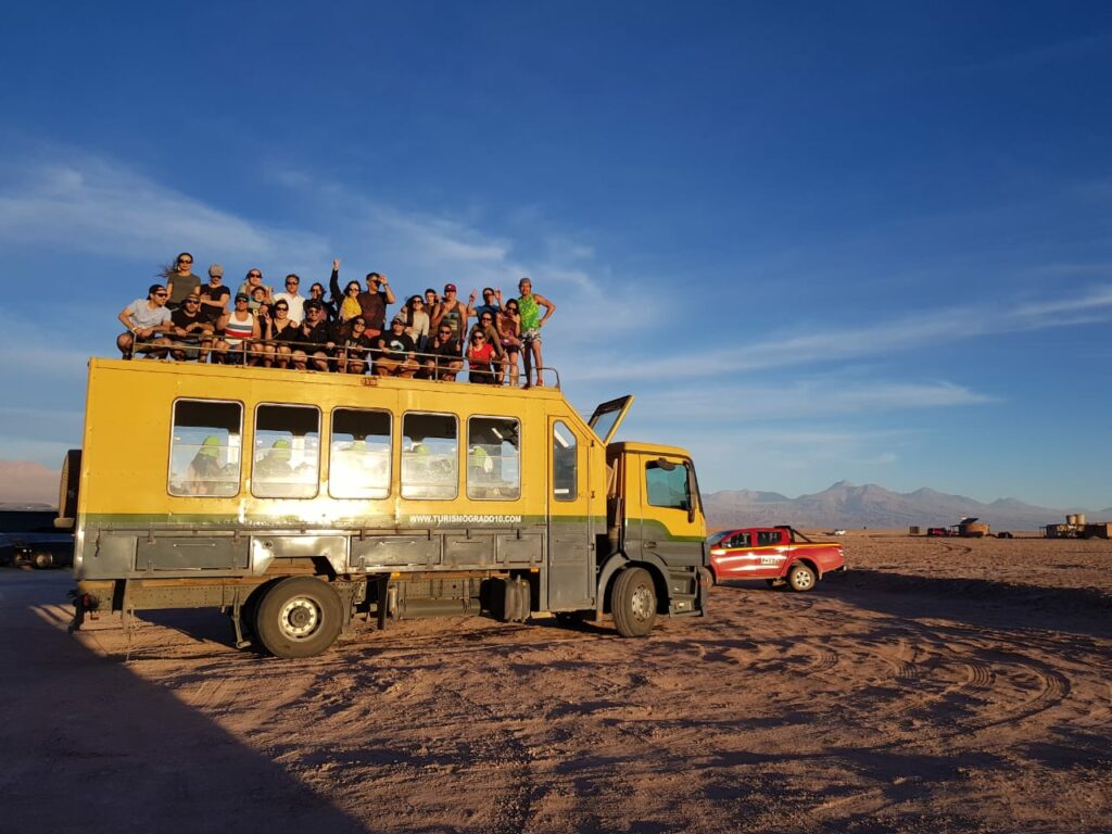 Caminhão cheio de pessoas no deserto