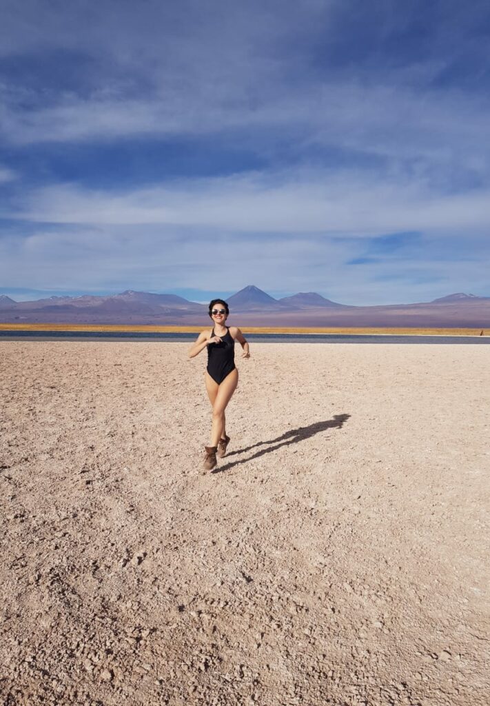 Mulher jovem correndo feliz na Laguna Cejar no deserto 