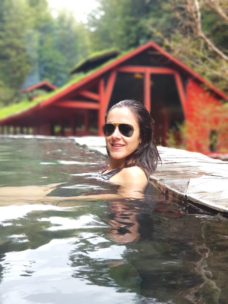 Termas Geométricas, Chile. Mulher em piscina de água quente natural com linda natureza ao fundo