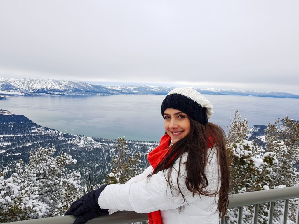 Mulher com roupa de neve em cima de observatório do Lake Tahoe e montanhas nevadas
