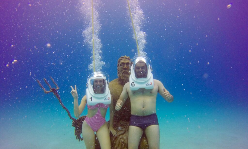 Casal mergulhando ao lado de Poseidon no Mar do caribe