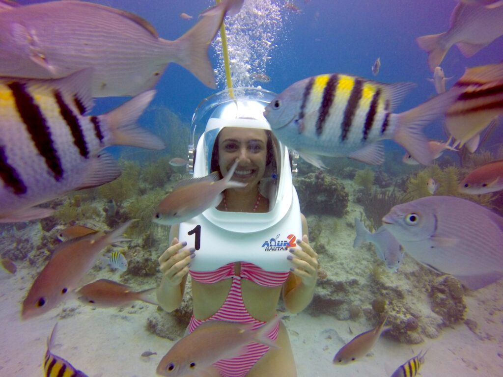 Mulher mergulhando no Mar do Caribe junto com peixes